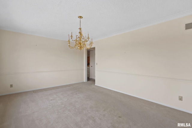 spare room with carpet floors, a textured ceiling, crown molding, and a chandelier