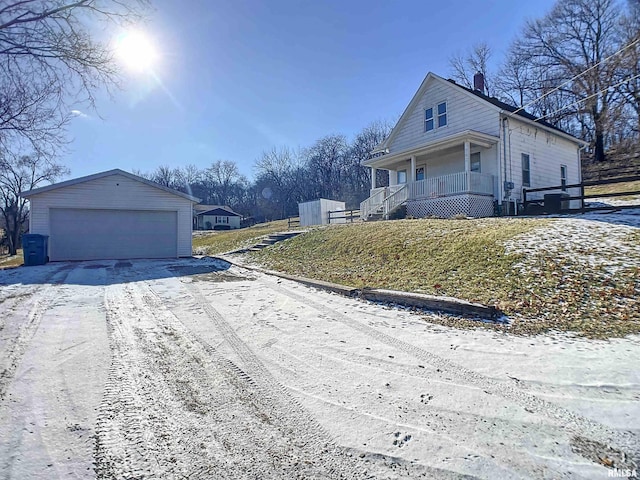 view of side of home with a porch, a garage, and an outbuilding