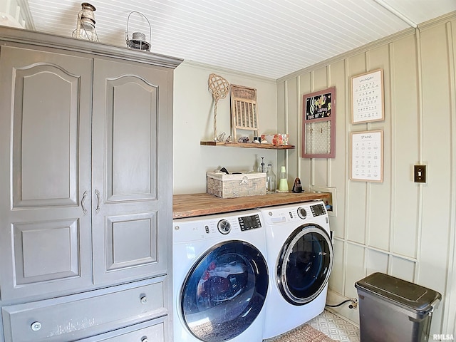 clothes washing area featuring crown molding and washer and clothes dryer