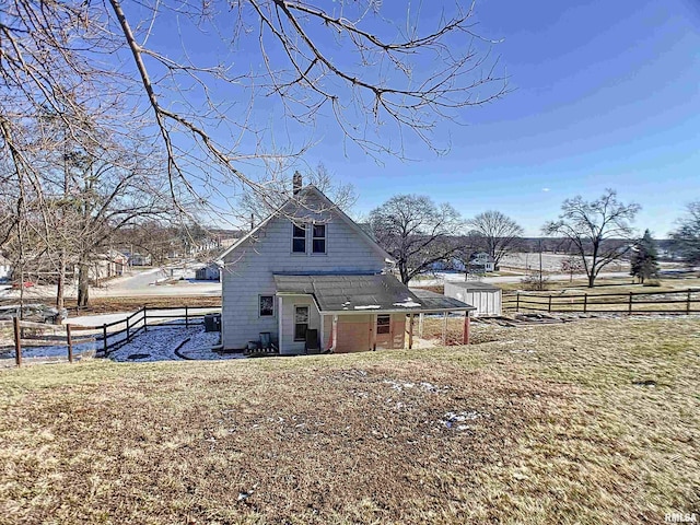 rear view of property featuring a lawn