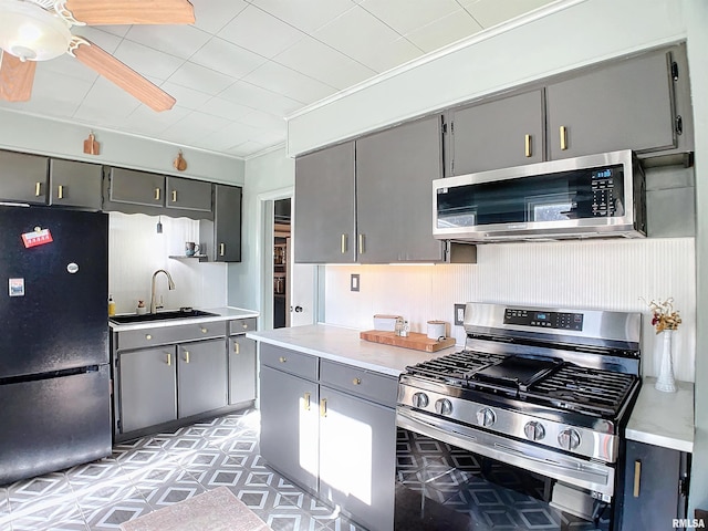 kitchen with ceiling fan, stainless steel appliances, gray cabinets, and sink