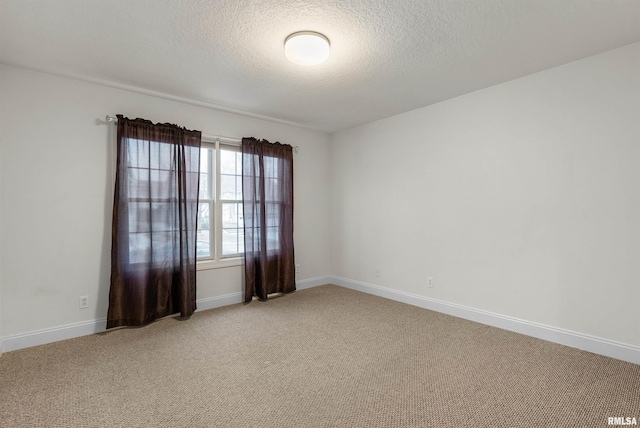 spare room featuring carpet and a textured ceiling