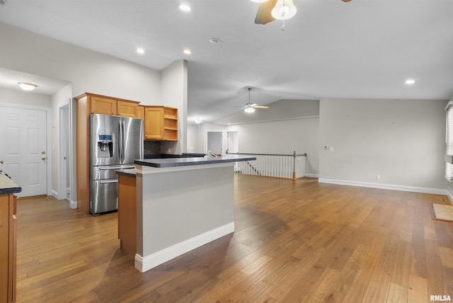 kitchen with vaulted ceiling, decorative backsplash, hardwood / wood-style floors, and stainless steel refrigerator with ice dispenser