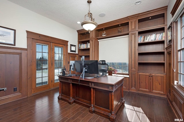 office space with a textured ceiling, wooden walls, and dark hardwood / wood-style floors