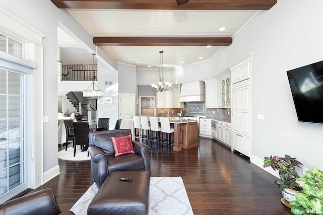 living room featuring beamed ceiling, sink, dark wood-type flooring, and an inviting chandelier