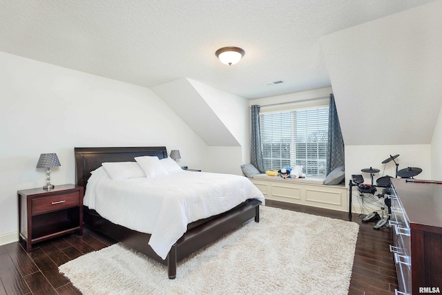 bedroom featuring a textured ceiling and vaulted ceiling