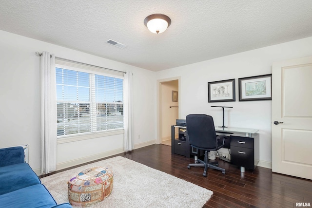 home office with a textured ceiling and dark hardwood / wood-style floors