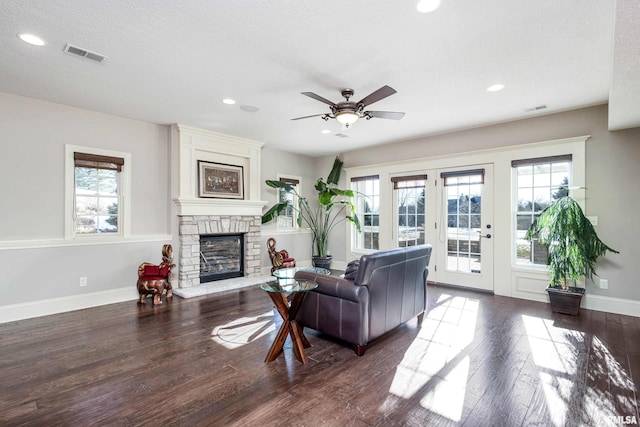 living room with a textured ceiling, dark hardwood / wood-style floors, and ceiling fan