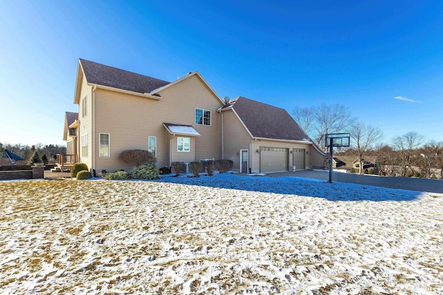 snow covered property with a garage