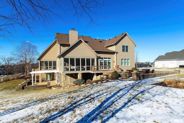 snow covered property with a sunroom