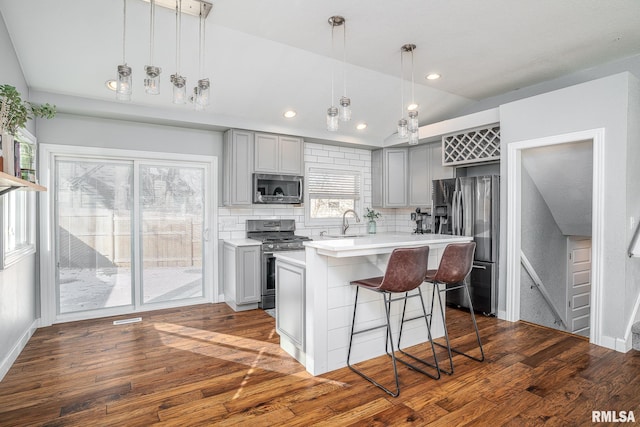 kitchen featuring appliances with stainless steel finishes, vaulted ceiling, and gray cabinetry