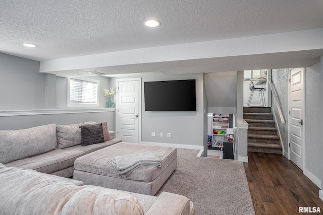 living room with a textured ceiling and dark hardwood / wood-style floors