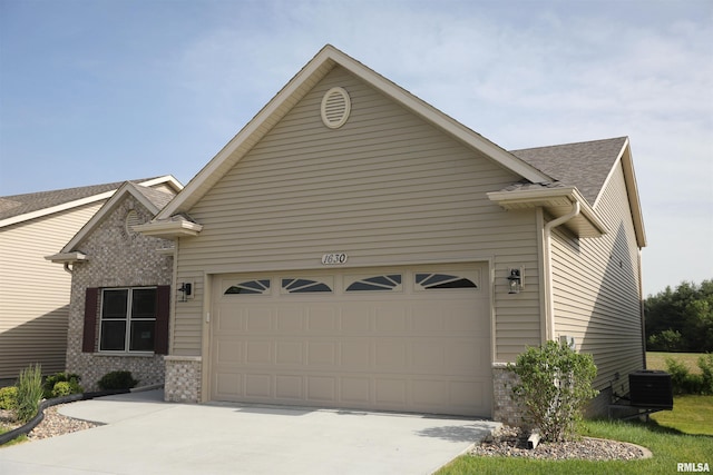 view of front of home with a garage and central AC