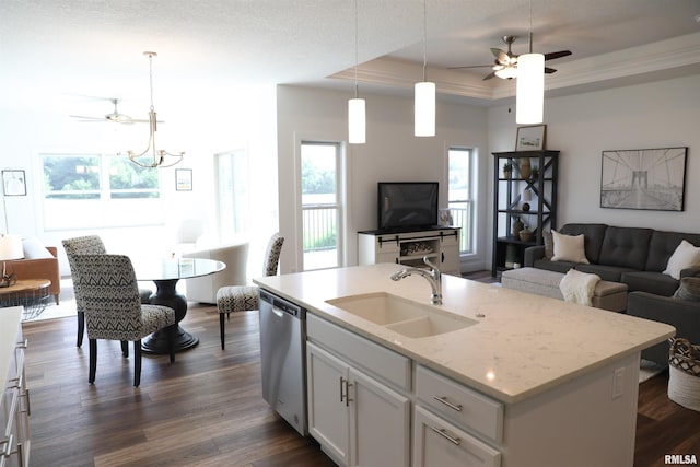 kitchen with stainless steel dishwasher, a raised ceiling, a kitchen island with sink, white cabinetry, and sink