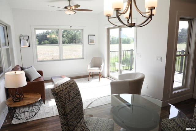 interior space featuring ceiling fan with notable chandelier and dark wood-type flooring