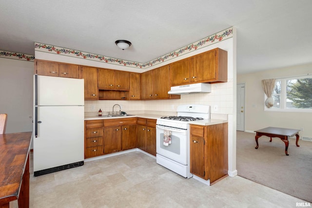 kitchen with white appliances, light carpet, and sink