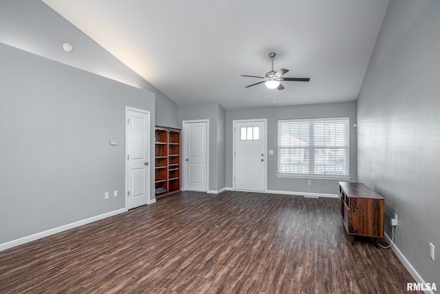 unfurnished living room featuring lofted ceiling, ceiling fan, dark wood finished floors, and baseboards