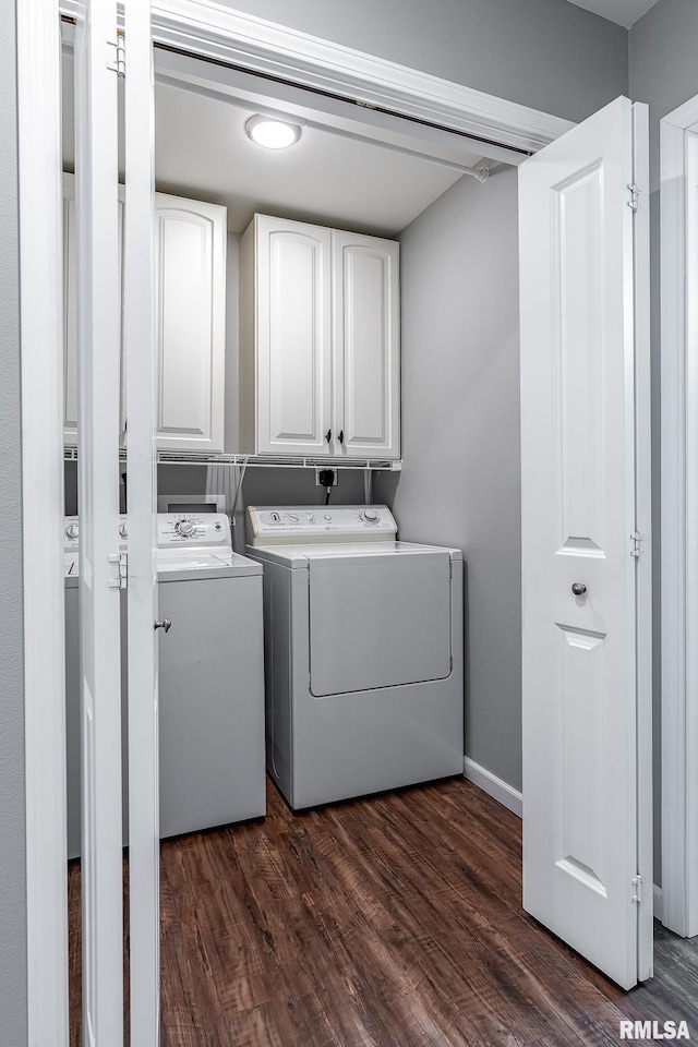 laundry area featuring dark hardwood / wood-style flooring, cabinets, and washer and clothes dryer