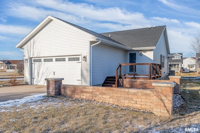 exterior space with central AC unit and a garage