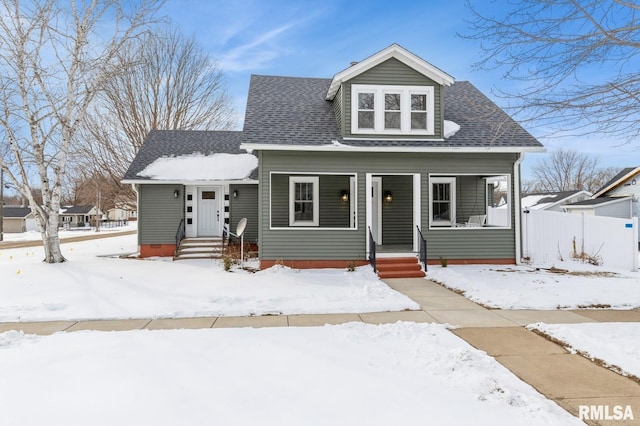 bungalow with covered porch and roof with shingles