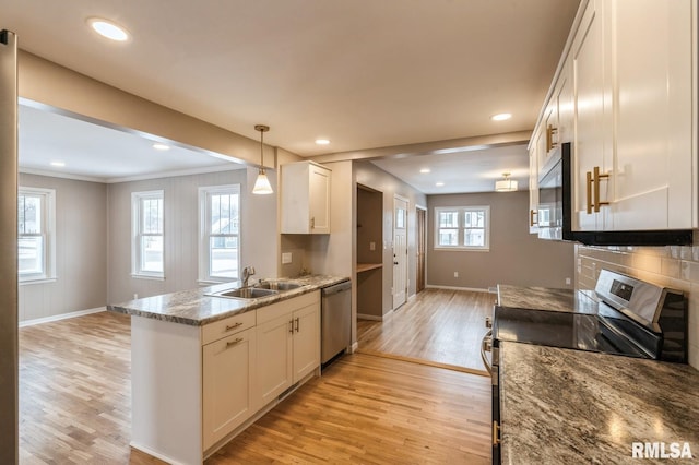 kitchen featuring white cabinets, appliances with stainless steel finishes, light wood-type flooring, light stone countertops, and pendant lighting