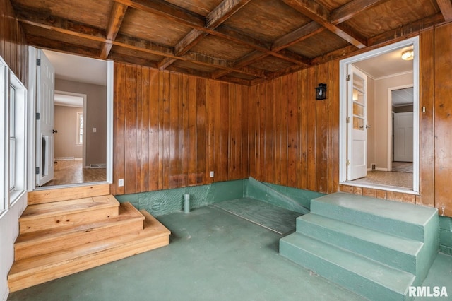 unfurnished room featuring concrete flooring and wood walls