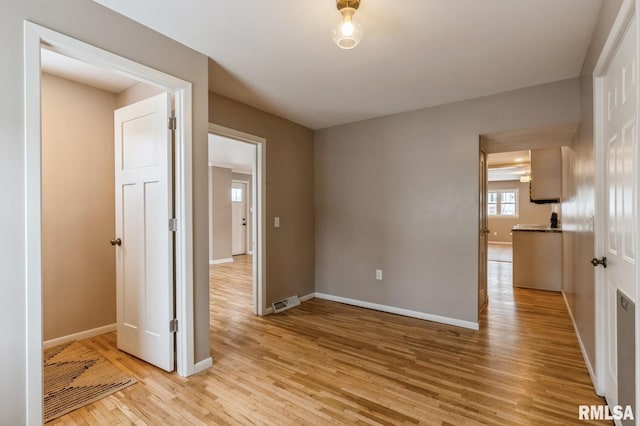 spare room with light wood-type flooring and baseboards