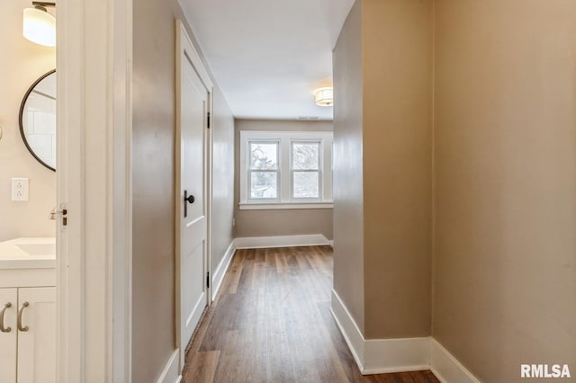 hall featuring dark wood finished floors and baseboards