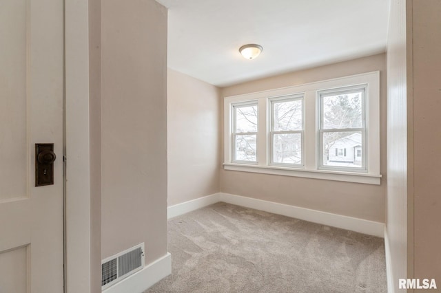 empty room featuring light carpet, baseboards, and visible vents