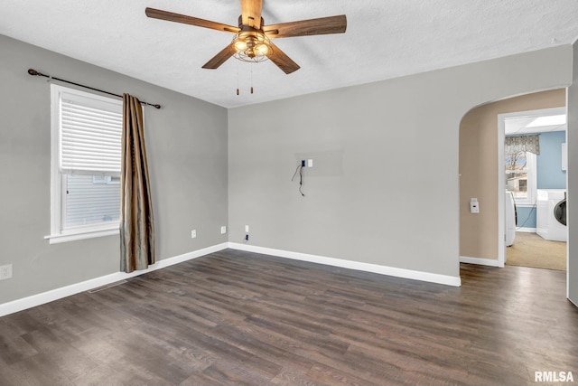 unfurnished room featuring independent washer and dryer, a textured ceiling, ceiling fan, and dark hardwood / wood-style floors