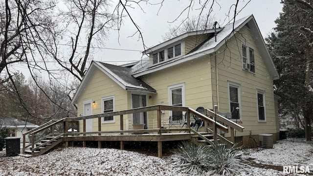 snow covered rear of property featuring a deck and cooling unit