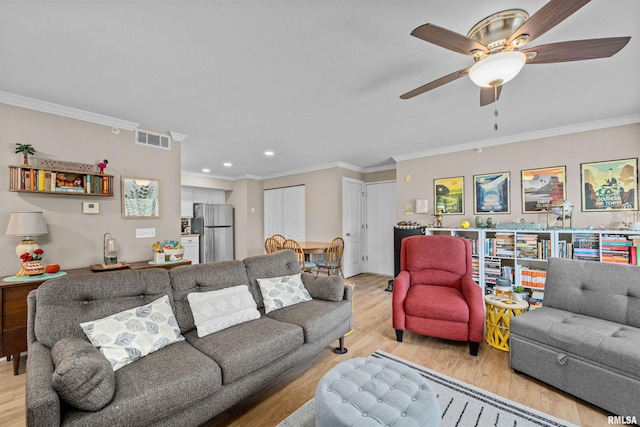 living room featuring ceiling fan, light wood-type flooring, and crown molding