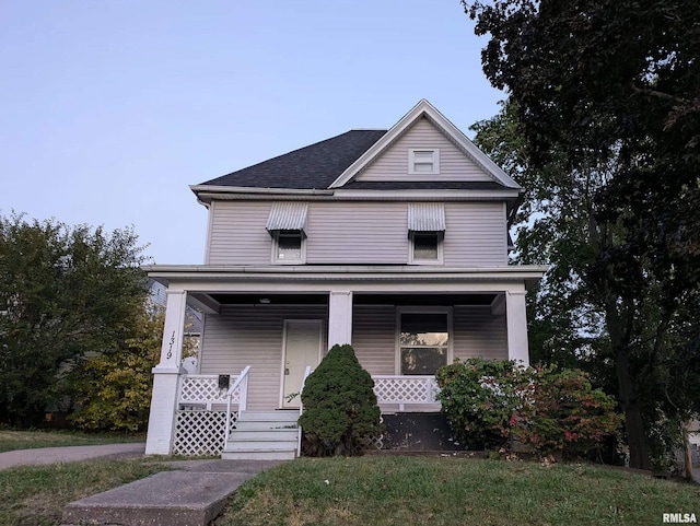 view of front of property featuring covered porch and a front lawn