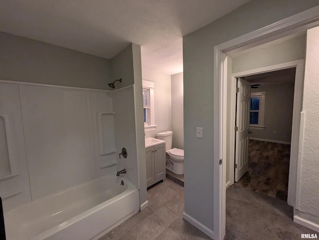 full bathroom with a textured ceiling,  shower combination, vanity, and toilet