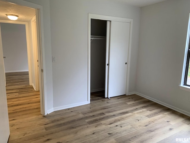 unfurnished bedroom featuring a closet and light hardwood / wood-style flooring