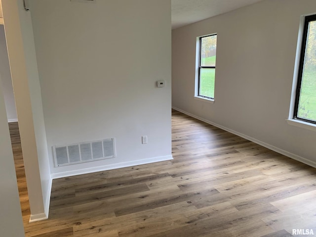 spare room featuring light hardwood / wood-style floors and plenty of natural light