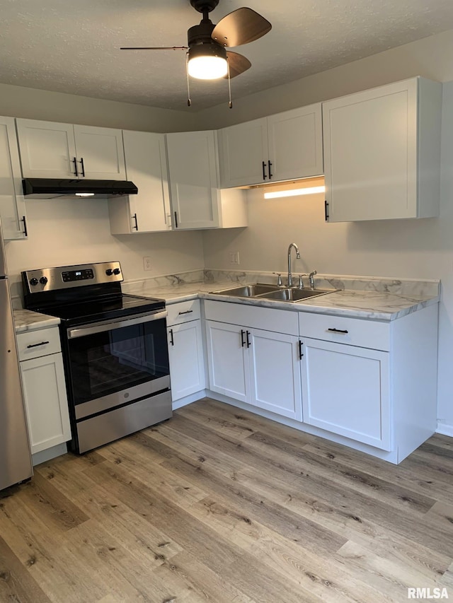 kitchen featuring white cabinetry, ceiling fan, stainless steel appliances, light hardwood / wood-style flooring, and sink