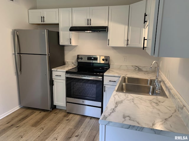 kitchen featuring light hardwood / wood-style floors, sink, white cabinetry, appliances with stainless steel finishes, and light stone counters