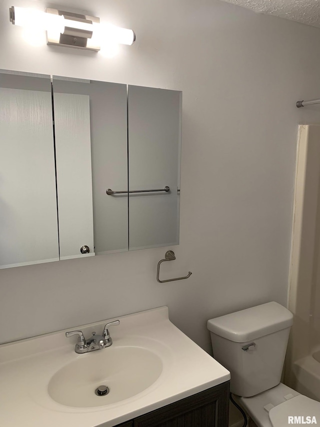 bathroom with a textured ceiling, toilet, and vanity