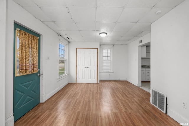 entryway with a drop ceiling and hardwood / wood-style flooring