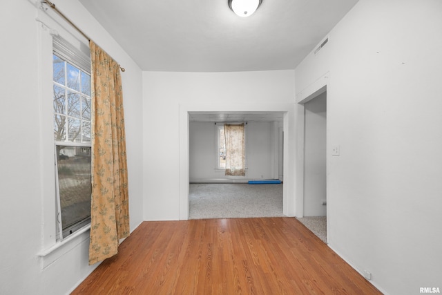 corridor with hardwood / wood-style flooring