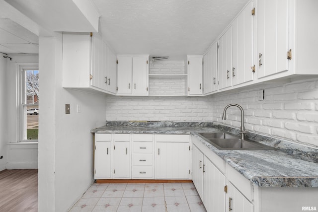 kitchen with white cabinets, backsplash, a wealth of natural light, and sink