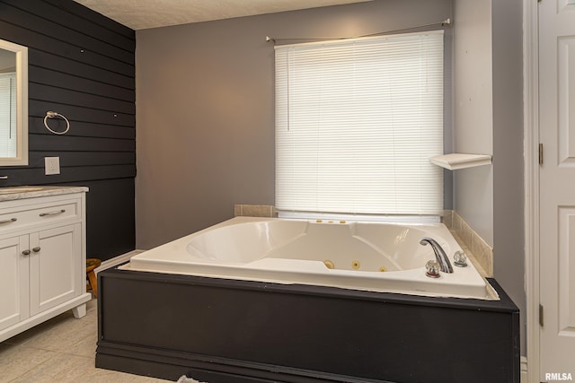 bathroom with vanity, tile patterned flooring, wood walls, a tub to relax in, and a textured ceiling