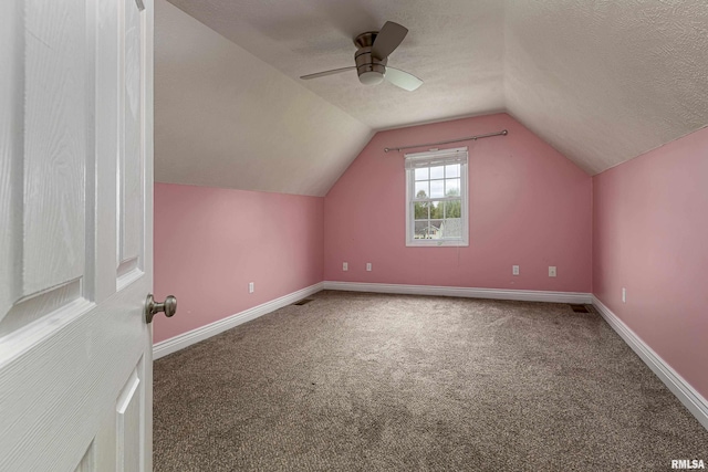 additional living space featuring a textured ceiling, ceiling fan, carpet, and lofted ceiling