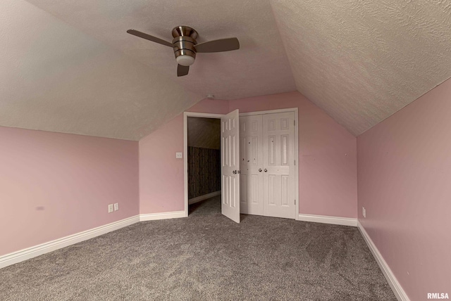 bonus room with ceiling fan, dark carpet, a textured ceiling, and lofted ceiling