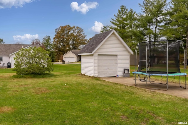 garage featuring a lawn and a trampoline