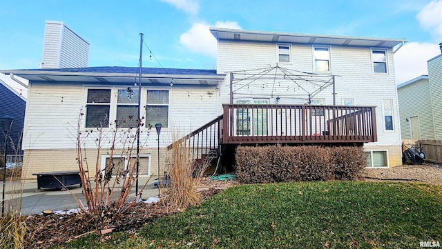 rear view of house featuring a patio area, a deck, and a lawn