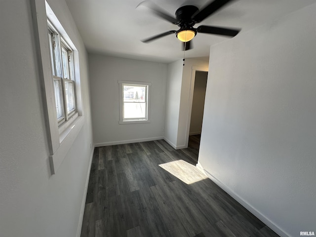 empty room with ceiling fan and dark wood-type flooring