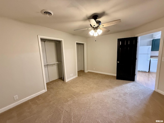 unfurnished bedroom with ceiling fan, light colored carpet, and white refrigerator