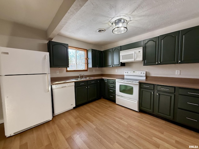 kitchen featuring white appliances, a textured ceiling, beamed ceiling, sink, and light wood-type flooring